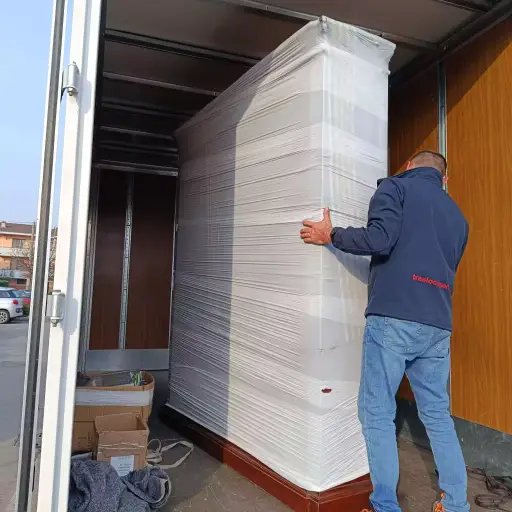 Traslocatore di VZ-Traslochi mentre carica una credenza grande nel furgone
